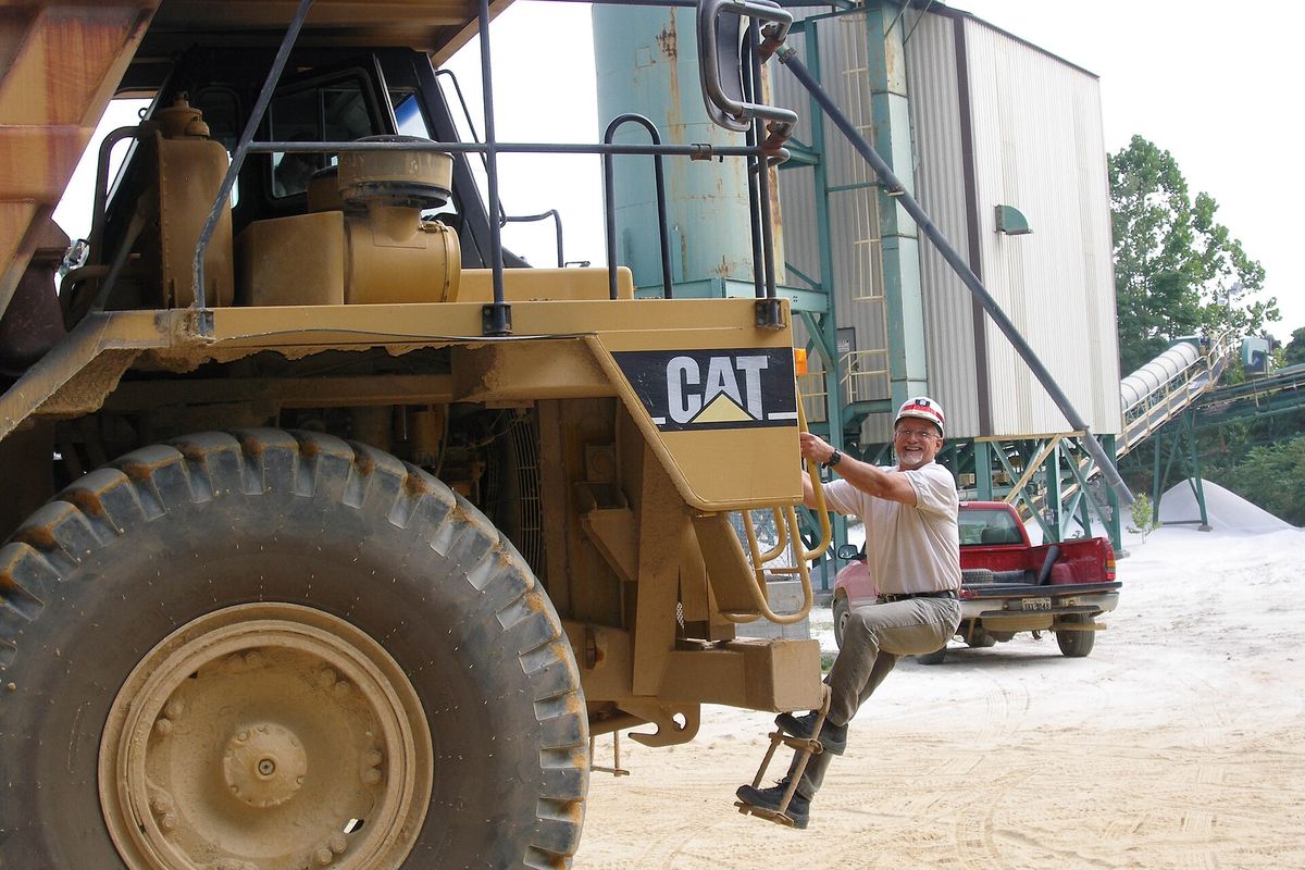 Large yellow haul truck beside an aggregate plant